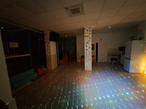 Habitación oscura con luces reflejadas en el suelo y muebles indistintos.